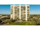 Full exterior view of a white 20-story condominium building featuring lush landscaping and multiple balconies at 3301 Bayshore Blvd # 704D, Tampa, FL 33629