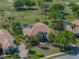 An aerial view of a luxury home with a pool, golf course, and mature trees at 33818 Americana Ave, Dade City, FL 33525