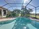 Inviting screened-in pool with integrated spa and lush landscaping, perfect for relaxation and outdoor enjoyment at 33818 Americana Ave, Dade City, FL 33525