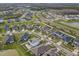 An aerial view captures a well-planned community with numerous homes, ponds, and roadways amid lush greenery at 34159 Astoria Cir, Wesley Chapel, FL 33545