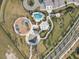 Aerial view of community playground, pool and amenity center in a planned community at 34159 Astoria Cir, Wesley Chapel, FL 33545