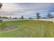 Large, well-kept backyard with a white fence, green grass, and young trees for a serene setting at 34159 Astoria Cir, Wesley Chapel, FL 33545