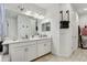 Well lit bathroom with a double sink vanity and ceramic tile floors at 34159 Astoria Cir, Wesley Chapel, FL 33545