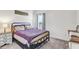 Inviting bedroom with a metal frame bed, nightstand, and a window at 34159 Astoria Cir, Wesley Chapel, FL 33545
