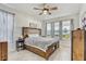 Bright bedroom with a wooden bed frame, striped curtains, and plenty of natural light from the windows at 34159 Astoria Cir, Wesley Chapel, FL 33545