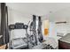 Well-lit exercise room with treadmill, elliptical machine, stationary bike, and a comfortable sitting area at 34159 Astoria Cir, Wesley Chapel, FL 33545