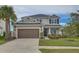 Charming two-story home featuring a well-manicured lawn, a two-car garage, and beautiful landscaping at 34159 Astoria Cir, Wesley Chapel, FL 33545
