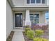 A detailed view of the front porch with beautiful landscaping and a black front door at 34159 Astoria Cir, Wesley Chapel, FL 33545