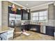 Modern kitchenette featuring stainless steel appliances, dark cabinetry, and stylish backsplash at 34159 Astoria Cir, Wesley Chapel, FL 33545