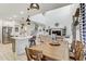 Open-concept living space featuring a kitchen island, dining table, and comfortable seating area with high ceilings at 34159 Astoria Cir, Wesley Chapel, FL 33545