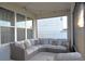 Relaxing outdoor covered patio with comfortable sectional sofa and stylish black and white pillows at 34159 Astoria Cir, Wesley Chapel, FL 33545