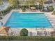 Aerial view of community pool with lane lines, surrounding lounge chairs, and covered seating at 34159 Astoria Cir, Wesley Chapel, FL 33545