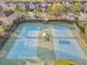 Aerial view of community tennis courts featuring nets and covered seating at 34159 Astoria Cir, Wesley Chapel, FL 33545