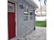 Side view of a home featuring a red door and concrete patio at 3419 W Empedrado St, Tampa, FL 33629