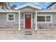Charming home featuring a red door, stone accents, and a welcoming front porch at 3419 W Empedrado St, Tampa, FL 33629