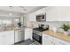 Open kitchen features stainless steel appliances, granite countertops, and stylish cabinetry at 3419 W Empedrado St, Tampa, FL 33629