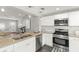 Open kitchen features stainless steel appliances, white cabinetry and granite countertops at 3419 W Empedrado St, Tampa, FL 33629