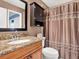Bathroom with granite vanity, wood cabinet, and shower with curtains at 4524 Southampton Ct # 4524, Tampa, FL 33618