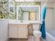 Bathroom features toilet, vanity and wallpaper with tropical leaf pattern at 4525 Cove Cir # 705, St Petersburg, FL 33708