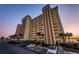 Multi-story tan condo building featuring numerous balconies and meticulous landscaping at 4525 Cove Cir # 705, St Petersburg, FL 33708