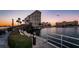 Picturesque view of the condo buildings with a bridge over the water, lush landscaping and benches at 4525 Cove Cir # 705, St Petersburg, FL 33708