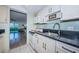 Convenient kitchen adjacent to living area, featuring white appliances and blue backsplash at 4525 Cove Cir # 705, St Petersburg, FL 33708