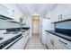 Bright kitchen with white cabinetry, black countertops, and modern appliances at 4525 Cove Cir # 705, St Petersburg, FL 33708