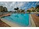 Relaxing pool area with lounge chairs, palm trees, and condo buildings in the background at 4525 Cove Cir # 705, St Petersburg, FL 33708