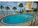 Refreshing pool with palm trees, lounge chairs, and waterfront views at 4525 Cove Cir # 705, St Petersburg, FL 33708