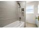 Modern bathtub and shower with neutral tile, gold hardware, and built-in shelving at 4568 40Th S St, St Petersburg, FL 33711