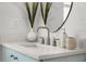 Bathroom vanity with stainless steel faucet, speckled countertop, decor and a round mirror at 4568 40Th S St, St Petersburg, FL 33711