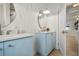 Bathroom featuring blue vanity with speckled countertop, round mirror and wood-look flooring at 4568 40Th S St, St Petersburg, FL 33711
