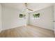 Bright bedroom featuring wood-look floors, a ceiling fan and two windows with neighborhood views at 4568 40Th S St, St Petersburg, FL 33711