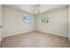 Bright bedroom featuring wood-look floors, a ceiling fan and two windows with palm tree views at 4568 40Th S St, St Petersburg, FL 33711