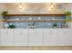 Stylish white cabinets, wooden shelves and blue tile backsplash, complete with decorative accents at 4568 40Th S St, St Petersburg, FL 33711