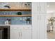 Elegant kitchen featuring blue backsplash, stylish shelves, and custom white cabinetry at 4568 40Th S St, St Petersburg, FL 33711