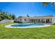 Landscaped backyard with a pool, brick patio, and a covered lounge area at 4568 40Th S St, St Petersburg, FL 33711
