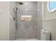 Walk-in shower featuring light tile, gold shower head, and recessed shelves at 4568 40Th S St, St Petersburg, FL 33711