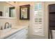 Bathroom vanity features white cabinets, light countertops, and a dark medicine cabinet at 476 Rebstock Blvd, Palm Harbor, FL 34683