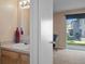 Bathroom area featuring a vanity with sink, mirror, and access to a bedroom with sliding door to the backyard at 5162 Sunridge Palms Dr # 5162, Tampa, FL 33617