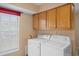Functional laundry room with washer, dryer, and overhead storage cabinets at 5162 Sunridge Palms Dr # 5162, Tampa, FL 33617