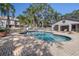 A view of the community pool and rec building with surrounding palm and mature trees at 5162 Sunridge Palms Dr # 5162, Tampa, FL 33617
