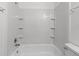 Bathroom tub and tiled shower with built-in corner shelves at 5225 Tennis Court Cir # 5225, Tampa, FL 33617