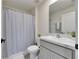 Bathroom featuring a sink, toilet, and shower with a light gray curtain at 5617 Flagstone Trl, Palmetto, FL 34221