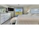 Bright bedroom with a large window, TV, white furniture, and plush carpet at 5617 Flagstone Trl, Palmetto, FL 34221
