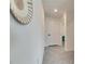 Hallway with decorative wall hanging, light tile floors, white walls, and a view into a bedroom at 5617 Flagstone Trl, Palmetto, FL 34221
