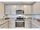Modern kitchen featuring granite countertops, stainless steel appliances, and gray cabinets at 5617 Flagstone Trl, Palmetto, FL 34221