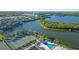 Expansive aerial view showcasing the community pool, tennis courts, and serene lake at 6401 99Th N Way # 15C, St Petersburg, FL 33708