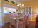 Charming dining room features a glass table, pink chairs, built-in hutch, and a view into the bright kitchen at 6401 99Th N Way # 15C, St Petersburg, FL 33708