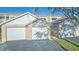 Exterior shot of the complex featuring individual garages for the townhomes, each with white doors and house numbers at 6401 99Th N Way # 15C, St Petersburg, FL 33708